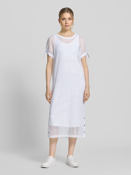 Frauenmodel trägt Semitransparentes Midikleid mit Rundhalsausschnitt von Marc Cain in Weiß, gerader Schnitt, Material-Mix, Ganzkörperansicht von vorne.