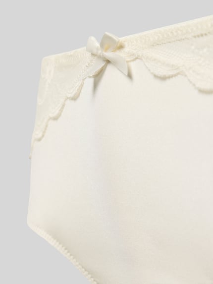 Frauenmodel trägt Slip mit Zierschleife Modell 'VITTORIA' von LASCANA, Unifarbenes-Design, Spitze, Mesh, Material-Mix, Nahaufnahme Oberkörper.