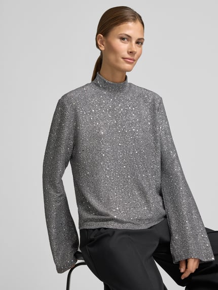 Frauenmodel trägt Langarmbluse mit strukturierter Optik und Mock Neck von JAKE*S WOMAN COLLECTION in Silber, Nahaufnahme Oberkörper.
