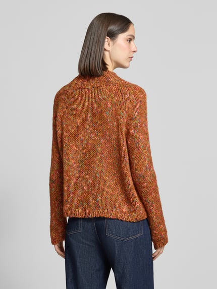 Frauenmodel trägt Strickpullover mit Stehkragen von Rich & Royal, orange-meliert, Material-Mix mit Mohairwoll-Anteil, Ganzkörperansicht Rückansicht.