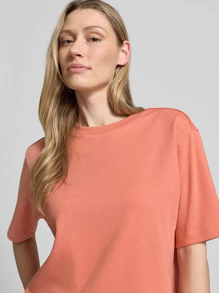 Modelka kobieca nosi T-Shirt mit Rundhalsausschnitt od JAKE*S STUDIO WOMAN z czystej bawełny, krój relaxed fit, kolor łososiowy, z obniżonymi ramionami, długość tyłu w rozmiarze S: 59 cm, zbliżenie na górną część ciała