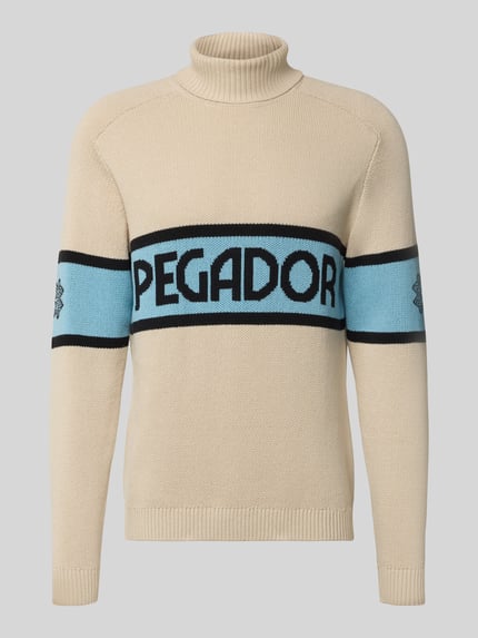 Produktfoto, Strickpullover mit Rollkragen van Pegador in beige met blauwe label-print, regular fit, geribde boorden, katoenmix, frontale weergave.