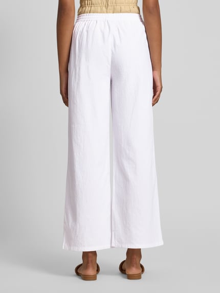 Frauenmodel trägt Stoffhose in verkürzter Passform Modell 'CISSIE' von Soyaconcept, reine Baumwolle, weiß, Wide Leg, Ganzkörperansicht Rückansicht.