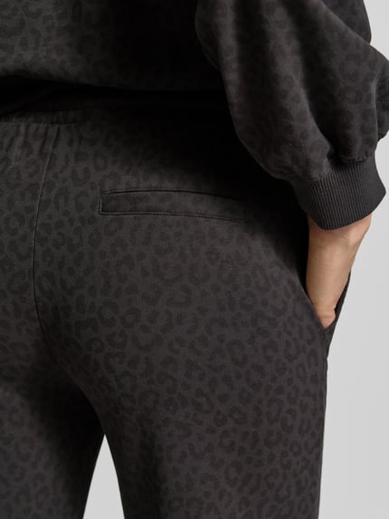 Vrouwenmodel draagt Wide Leg Sweatpants uit katoenmix van Juvia, donkergrijs met dierenprint, steekzakken, detailopname heup.
