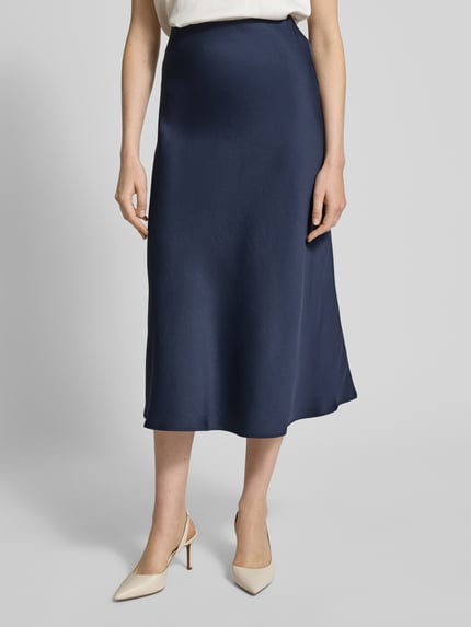 Vrouwenmodel draagt Midirok in A-lijn model 'URA' van Drykorn, materiaalmix met stretch, donkerblauw, totale lengte 87 cm, nahaufnahme onderlichaam.