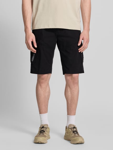 Mannenmodel draagt Relaxed Fit Cargoshorts uit puur katoen van s.Oliver BLACK LABEL, effen zwart met cargozakken en riemlussen, knoopsluiting; vooraanzicht hele lichaam.