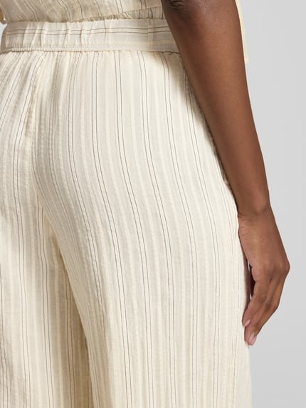 Frauenmodel trägt Hose mit elastischem Bund und Eingrifftaschen von Jake*s Studio Woman, cremefarbener Baumwoll-Mix, Detailaufnahme Hüfte