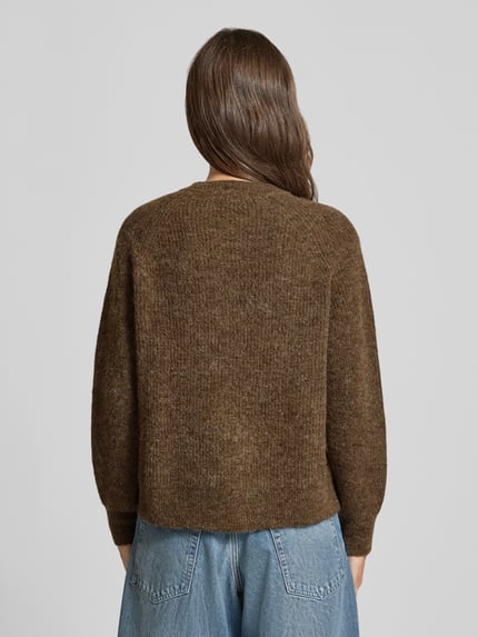 Frauenmodel trägt Relaxed Fit Strickjacke aus Woll-Mix Modell 'LULU' von Selected in Braun, grobe Stricktextur, Damen Strickjacke, Ganzkörperansicht Rückansicht.