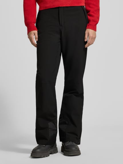 Männermodel trägt schwarze Flared Stoffhose mit Reißverschlusstaschen Modell 'KUMPULA' von LUHTA, aus Anzug-Stoff, Nahaufnahme Unterkörper.