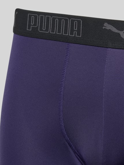 Mężczyznamodel nosi Slim Fit Trunk mit Logo-Stitching von PUMA, elastyczny materiał, krój slim fit, widoczne logo, zbliżenie na biodra.