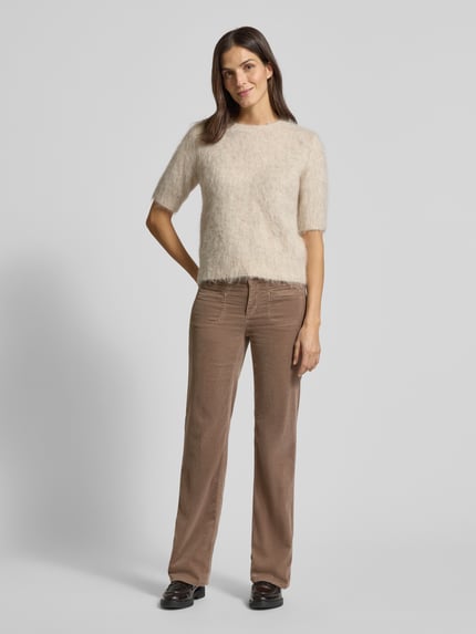 Frauenmodel trägt Bootcut Cordhose mit Eingrifftaschen Modell 'TESS' von Cambio, Baumwoll-Mix mit Modal-Anteil, braun, Ganzkörperansicht von vorne.