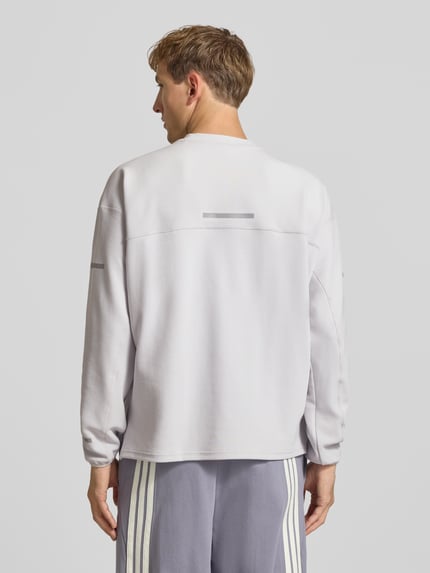 Männermodel trägt Regular Fit Sport-Langarmshirt mit Lyocell-Anteil von adidas Training in hellem Grau, glatte Textur, Ganzkörperansicht Rückansicht.