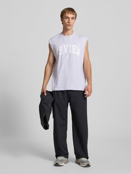 Mannenmodel draagt Tanktop met Logo-Print van REVIEW in lichtgrijs, puur katoen, recht model, ronde hals, logoprint, ruglengte maat M 68 cm, full body vooraanzicht.