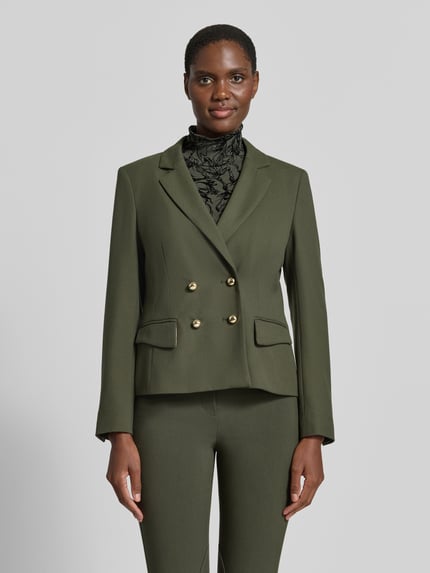 Frauenmodel trägt Slim Fit Blazer mit Reverskragen und Pattentaschen von Marc Cain in Olivgrün, Material-Mix, Zweireiher, Ganzkörperansicht von vorne.