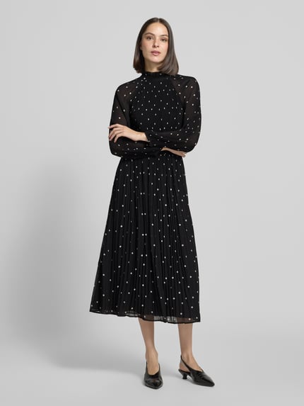 Frauenmodel trägt Midikleid im Allover-Look mit Plisseefalten von COMMA, schwarze A-Linie mit Stehkragen, Ganzkörperansicht von vorne.
