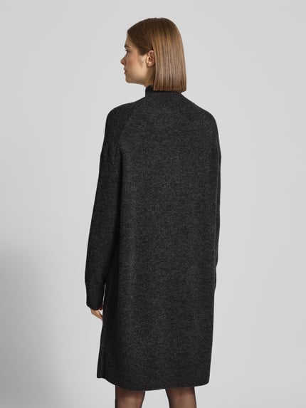 Kobiece model prezentuje Oversized Strickkleid aus Schurwoll-Mix od Marc O'Polo Denim, efekt: jednolity kolor, krój oversized, długość mini, wysokie zapięcie, długie rękawy, prążkowane wykończenie rękawów i dołu, wykończenie: dzianina, mieszanka żywej wełny, widok całej sylwetki od tyłu.