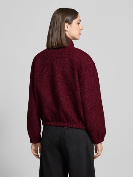 Vrouwenmodel draagt Jacke mit Stehkragen Modell 'La44ra' van ZABAIONE in bordeaux, loose fit, opstaande kraag, steekzakken, elastische boorden, ruglengte maat S 55 cm, mouwlengte maat S 54 cm, structuurlook stof, ganzkörperansicht achteraan