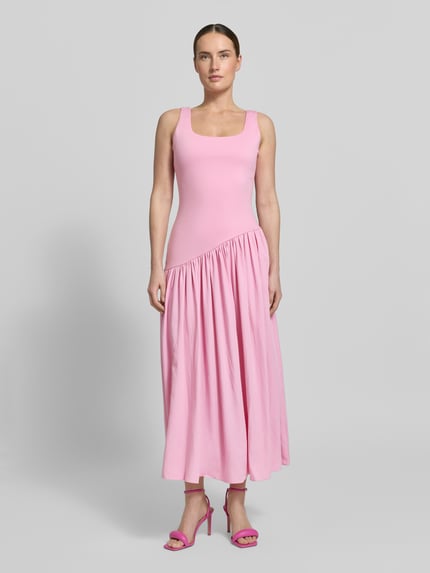 Vrouwenmodel draagt Midikleid mit Karree-Ausschnitt van Little Mistress in lichtroze, mix van materialen met stretch, aansluitende fit, asymmetrisch, vierkante halslijn, ruglengte maat 36: 113 cm, borstwijdte maat 36: 37 cm. Volledige lichaamsaanzicht van voren.