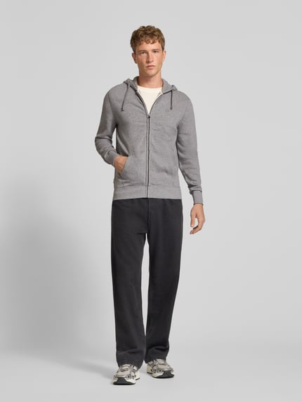 Männermodel trägt Regular Fit Sweatjacke aus Baumwoll-Mix mit Label-Detail von Superdry, grau, Kapuze, Känguru-Tasche, Ganzkörperansicht von vorne.
