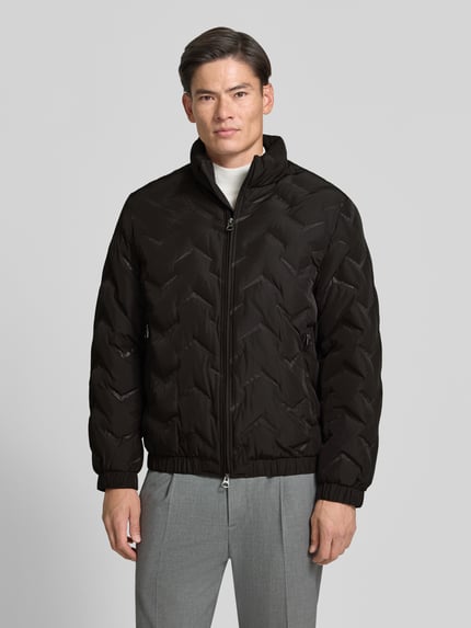 Männermodel trägt Steppjacke mit Stehkragen und Reißverschlusstaschen von Antony Morato, Schwarz mit Struktur, Regular Fit, Ganzkörperansicht von vorne. Rückenlänge 71 cm, Schulterbreite 50 cm, Brustweite 59 cm, Ärmellänge 66 cm.