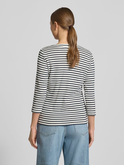 Frauenmodel trägt Regular Fit 3/4-Shirt aus Baumwoll-Mix von Tom Tailor mit Allover-Streifenmuster, U-Boot-Ausschnitt, Rückansicht.