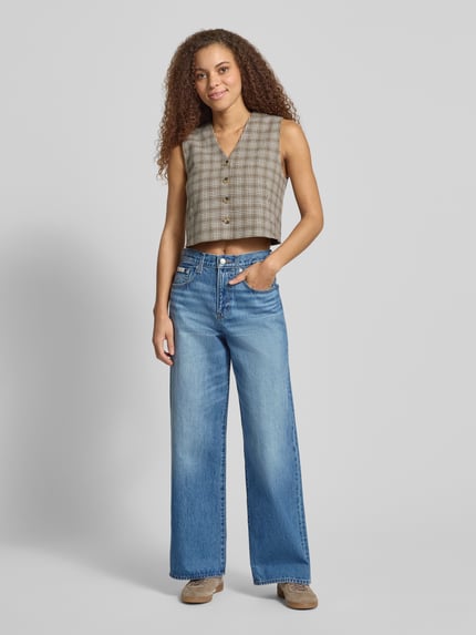 Frauenmodel trägt Wide Fit Jeans mit Label-Detail von Calvin Klein Jeans, Reine Baumwolle, Used-Look, Ganzkörperansicht von vorne.