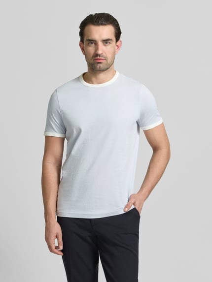 Männermodel trägt Slim Fit T-Shirt mit Rundhalsausschnitt von MCNEAL aus reiner Baumwolle, kurzärmelig, helles Design, Ganzkörperansicht von vorne.