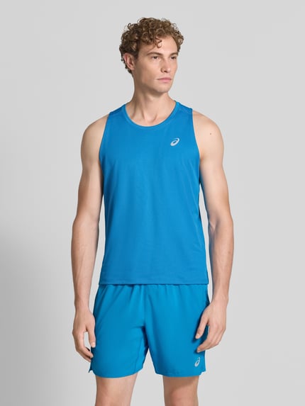 Männermodel trägt Regular Fit Top mit Logo-Print Modell 'Core' von ASICS TIGER in Blau, glatte Struktur, Ganzkörperansicht von vorne.