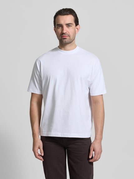 Męski model nosi Regular Fit T-Shirt aus reiner Baumwolle od MCNEAL, biały kolor, krój regular fit, przód, zdjęcie całej sylwetki