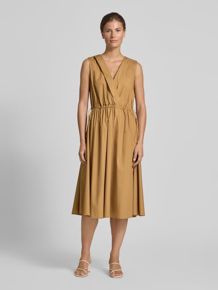 Frauenmodel trägt knielanges Cocktailkleid mit Kordelzug und Kordelstoppern von Rinascimento aus Reine Baumwolle, Taillierter Schnitt, V-Ausschnitt, in Beige, glatte Textur, Knielänge, Ganzkörperansicht von vorne.