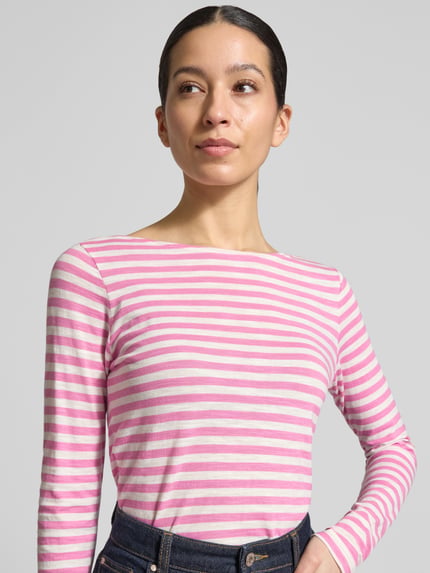 Frauenmodel trägt Regular Fit Langarmshirt aus reiner Baumwolle von Marc O'Polo, gestreift in Rosa und Weiß, U-Boot-Ausschnitt, Nahaufnahme Oberkörper.
