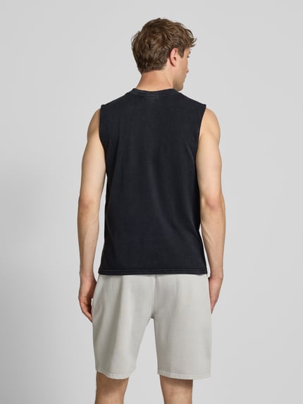 Männermodel trägt Tanktop mit Label-Stitching und Rundhalsausschnitt von Pegador aus Reine Baumwolle im Relaxed-Fit, Rückenlänge 66 cm, Ganzkörperansicht Rückansicht.