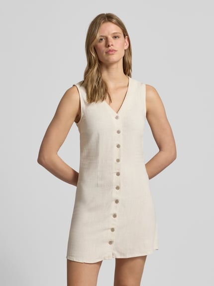 Modelka kobieca nosi Tailliertes Freizeitkleid aus Viskose-Leinen-Mix Modell 'SIESTA' od Only, efekt: jednolity kolor, krój: taliowany, długość mini, dekolt w serek, listwa guzikowa, bez rękawów, wykończenie materiału: cieniowana przędza, materiał: mieszanka wiskozy i lnu, zdjęcie całej sylwetki z przodu.