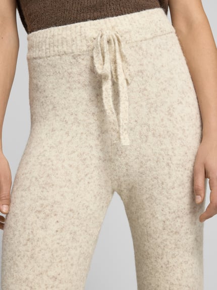 Frauenmodel trägt Hose mit Strickoptik von VERO MODA in Creme mit elastischem Bund und Tunnelzug, Nahaufnahme Oberkörper, Damenmode.