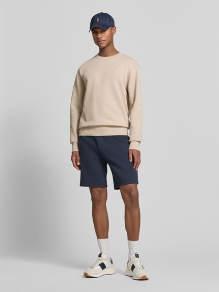 Męski model nosi Relaxed Fit Sweatshirt aus reiner Baumwolle od Polo Ralph Lauren, efekt: jednolity kolor, krój relaxed fit, detal z logo, okrągły dekolt, długie rękawy, prążkowane wykończenia, dzianina dresowa, 100% bawełna, całopostaciowy widok z przodu.