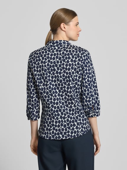 Frauenmodel trägt Regular Fit Bluse mit V-Ausschnitt und 3/4-Arm von More & More, Baumwoll-Elasthan-Mix, Allover-Look, Ganzkörperansicht Rückansicht.