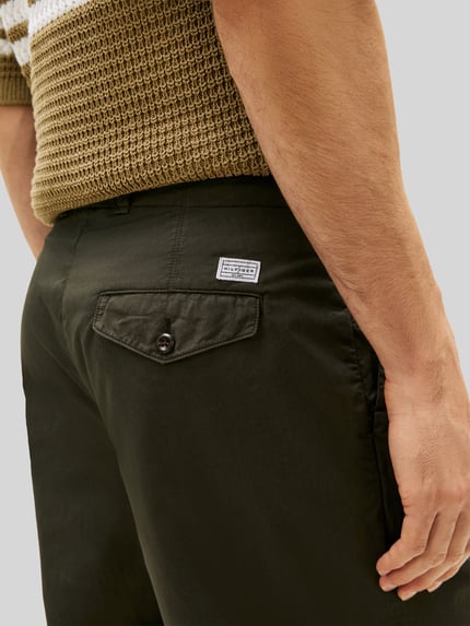 Männermodel trägt Loose Fit Hose mit Bundfalten von Tommy Hilfiger, Optik: Unifarben, reine Baumwolle, Detailaufnahme Rückansicht.