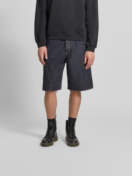 Männermodel trägt Straight Fit Shorts in Denim-Optik von Kenzo aus puur katoen, cargozakken, knoop- en ritssluiting, donkerblauw, ganzkörperansicht von vorne.