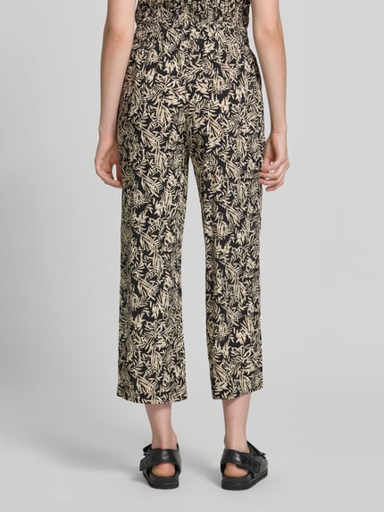 Frauenmodel trägt Straight Fit Stoffhose aus reiner Viskose-Mix Modell 'Faye' von Soyaconcept, floraler Allover-Print, verkürzte Passform, elastischer Bund mit Tunnelzug, Ganzkörperansicht Rückansicht.
