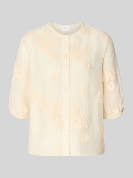 Produktfoto, Regular Fit Bluse mit floralem Zierbesatz von Jake*s Collection, hellgelber Baumwoll-Mix, Halbarm, strukturierte Oberfläche, Rundhalsausschnitt mit Bordüre, durchgehende Knopfleiste, elastische Ärmelabschlüsse, florale Texturen, schlicht vor grauem Hintergrund.