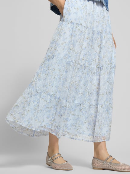 Frauenmodel trägt Ausgestellter Maxi-Rock mit elastischem Bund Modell 'LELIZA' von Only mit Optik:Allover-Muster, Regular-Fit, Maxi-Länge, gerade Saum und Dobby-Materialverarbeitung, Ganzkörperansicht von vorne.
