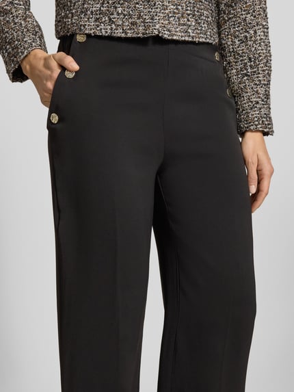 Vrouwenmodel draagt Stoffhose aus Viskose-Mix Modell 'Damai' van B.Young, zwart, wijde pijp, knopen, elastische tailleband, detailopname heup.