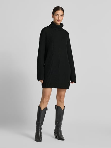 Frauenmodel trägt Strickkleid mit Rollkragen von Liu Jo White, gerader Schnitt, schwarze Farbe, grobe Textur, Ganzkörperansicht von vorne. Damen Strickkleid von Liu Jo, Material-Mix mit Woll-Anteil, Minikleid, Knöpfe, Rückenlänge 88 cm, Brustweite 52 cm, Ärmellänge 54 cm.