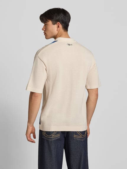 Männermodel trägt Relaxed Fit Poloshirt in Strick-Optik Modell 'Tellero' von Pegador, Reine Baumwolle, Kurzärmelig, Rückansicht, Ganzkörperansicht
