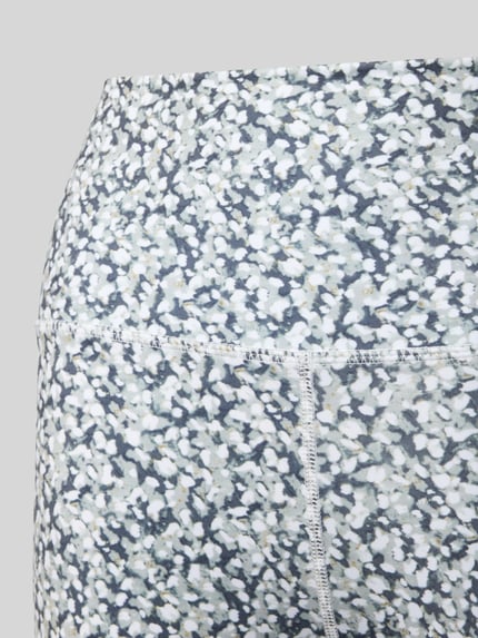 Vrouwenmodel draagt Slim Fit Leggins met brede band van VARLEY, elastische materiaalmix, multicolor dessin, detailopname rugzijde.