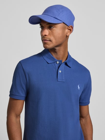 Męski model nosi Poloshirt mit Label-Stitching od Polo Ralph Lauren, niebieska bawełna, regular fit, krótki rękaw, logo z przodu, półzbliżenie torsu.