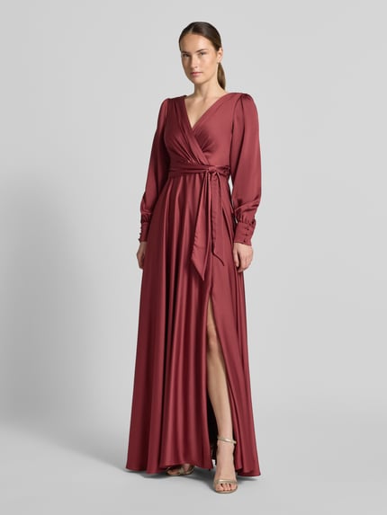 Frauenmodel trägt Tailliertes Abendkleid mit Bindegürtel von Jake*s Cocktail in Bordeauxrot, fließendes Material, Ganzkörperansicht von vorne.