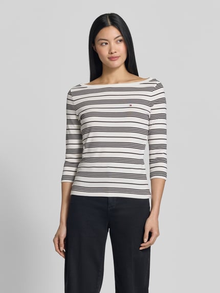 Frauenmodel trägt Slim Fit T-Shirt aus reiner Baumwolle von Tommy Hilfiger, gestreift in Weiß und Schwarz, Ganzkörperansicht von vorne, Damen T-Shirt von Tommy Hilfiger.