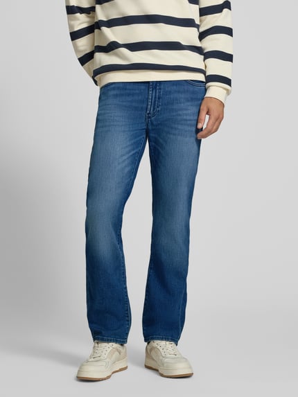 Männermodel trägt Relaxed Fit Jeans aus Baumwoll-Mix Modell 'Clint' von Brax in mittelblauem Denim, Herren Wide & Loose Fit Jeans, Ganzkörperansicht von vorne.