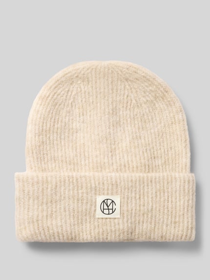 Produktfoto, Mütze aus elastischem Woll-Mix mit Alpaka-Anteil von MSCH Copenhagen in Beige mit breitem Umschlag und Label-Patch auf grauem Hintergrund.